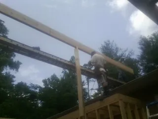 Carpenter setting a ridge beam over a new addition frame — Ice Dam Removal by Roofing Brothers in Melvern