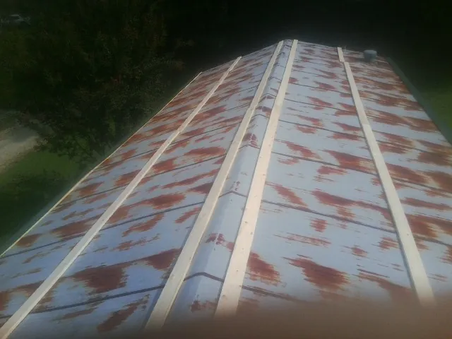 Rusted metal roof panels with new wood purlins before replacement — Storm Damage Roof Repair in Melvern by Roofing Brothers