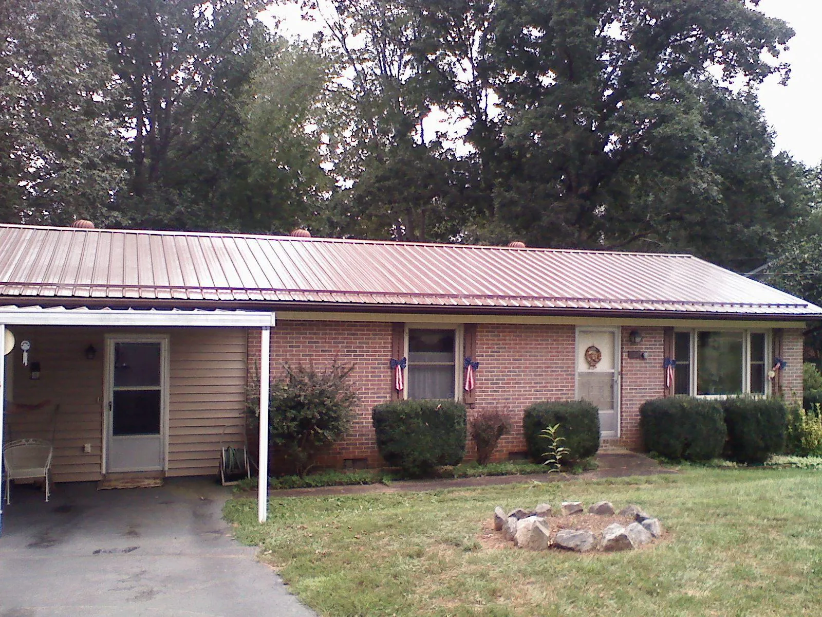 Bronze metal roof and carport on a brick ranch home — Roof Repair work by our crew in Melvern